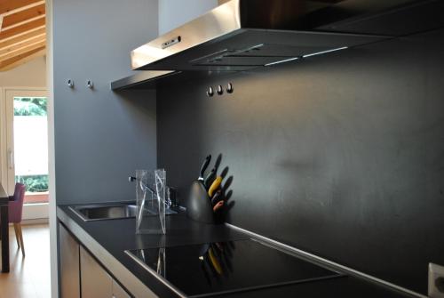 a black kitchen with a sink and a stove at Casa Bianca Apartments in Como