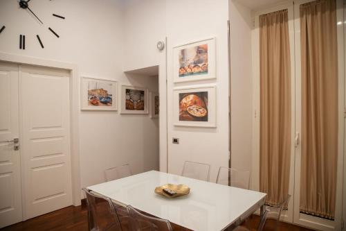 une salle à manger blanche avec une table et des chaises blanches dans l'établissement HELLO CHIAIA NAPOLI by Progecta srl, à Naples