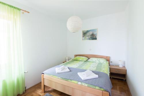a bedroom with a bed with two towels on it at Apartment Lucy in Kožino