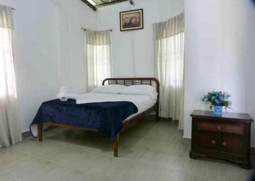 une chambre avec un lit, une table et des fenêtres dans l'établissement Casa de Campo - Jacuzzi y Río en Santo Domingo, à Santo Domingo de los Colorados