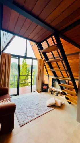 a large living room with a couch and large windows at Casa Girassol in Teresópolis