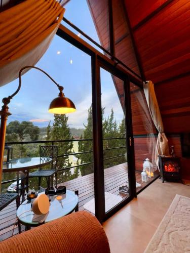 a room with a balcony with a table and a large window at Casa Girassol in Teresópolis