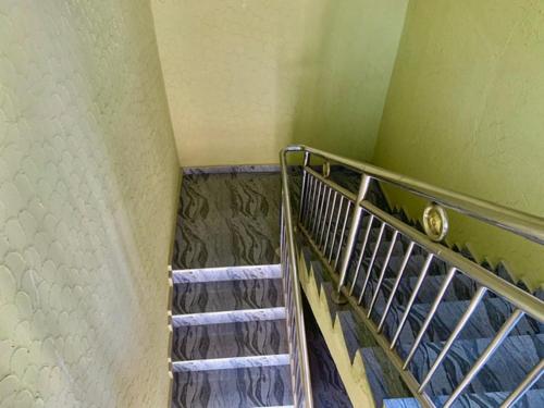 a metal staircase in a room with green walls at Oxford Villa Apartment in Nnewi