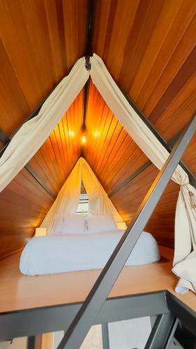 a bed in a tent with a wooden ceiling at Casa Girassol in Teresópolis