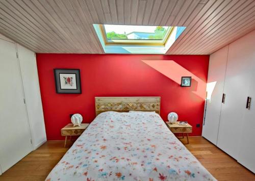 une chambre avec un grand lit avec un mur rouge dans l'établissement Beau duplex au calme en pleine nature avec piscine, à Mougins