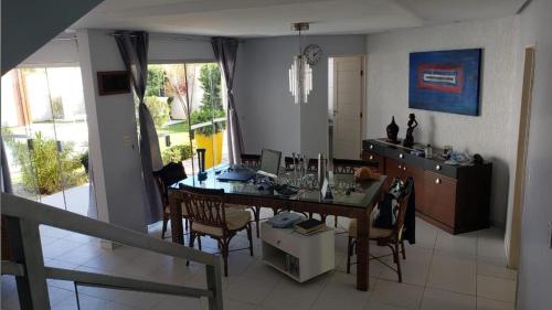 a kitchen and dining room with a table and chairs at Sonho de Verão in Paripueira