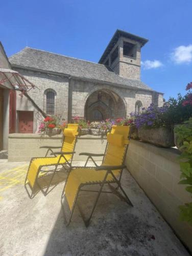 a group of yellow chairs sitting on a patio at Maison La vie de l'Aubrac - Gîte Lo Bel Peis in Saint-Symphorien-de-Thénières