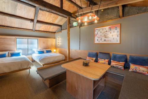 a hotel room with two beds and a table and chairs at KAON Taisho renovated 100-year-old private house in Osaka