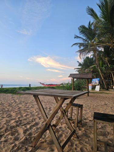 a wooden picnic table on a sandy beach at Suda Villa Bentota in Bentota