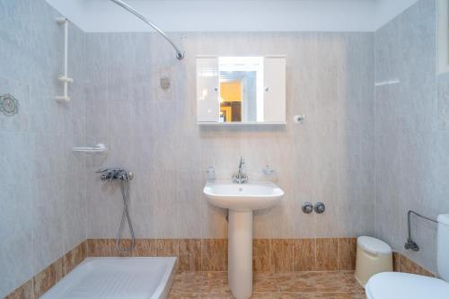 a bathroom with a sink and a toilet at Lemonia Apartments Kefalonia in Andipáta Erísou