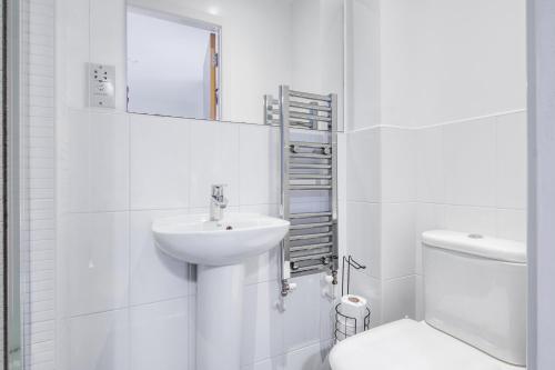 a white bathroom with a sink and a toilet at Comfy Home-Windrush Grove in Birmingham