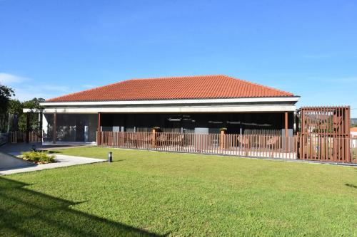 a house with a fence and a grass yard at Alminhas da Mindua in Vitorino dos Piães