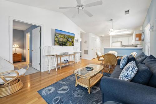 a living room with a blue couch and a table at 53E Bayside Birdie condo in Pawleys Island