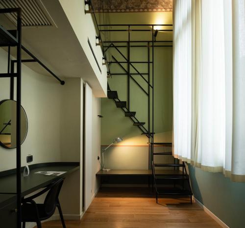 a room with a desk and a spiral staircase at I Portici Hotel Bologna in Bologna