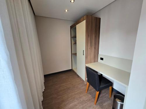 a room with a desk and a closet at Mercure Sao Paulo JK in Sao Paulo