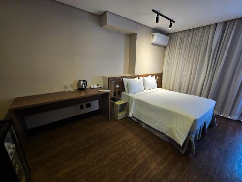a hotel room with a bed and a desk at Mercure Sao Paulo JK in Sao Paulo