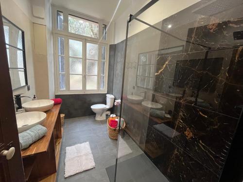 a bathroom with two sinks and a glass shower at RDC maison de maitre pour 6 personnes avec piscine et jacuzzi in Bastia