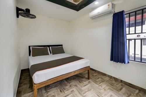 a small bed in a room with a window at Buraimi Apartments in Cochin