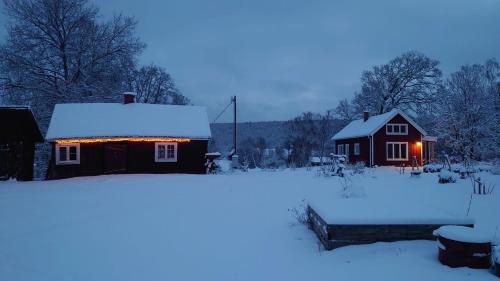 a house covered in snow in front of a house at Neues Ökohaus in traumhafter Lage direkt am Fluss in Västra Årena