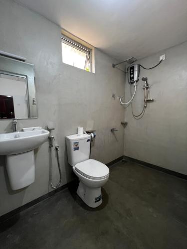 a bathroom with a toilet and a sink at Leafy Madiha in Matara
