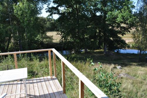 a wooden bridge with a bench and a pond at Neues Ökohaus in traumhafter Lage direkt am Fluss in Västra Årena