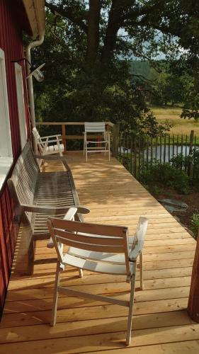 a wooden deck with a bench on a house at Neues Ökohaus in traumhafter Lage direkt am Fluss in Västra Årena
