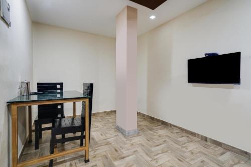 a room with a table and a tv on a wall at Buraimi Apartments in Cochin