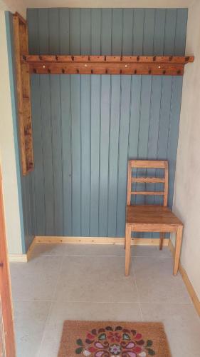 a wooden chair in a room with a blue wall at Neues Ökohaus in traumhafter Lage direkt am Fluss in Västra Årena
