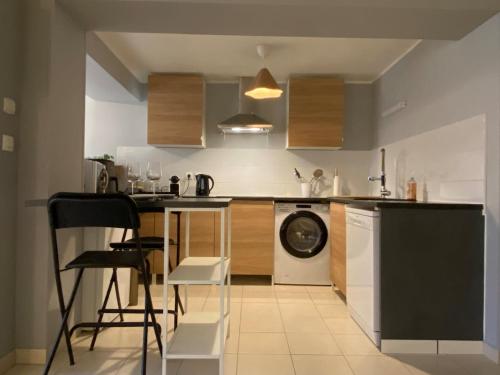 une cuisine avec un lave-linge et un lave-vaisselle dans l'établissement Le Nid à Bulles Scandinave, à Vernon