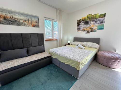 een slaapkamer met een bed en een poef bij Villa Daja in Biograd na Moru