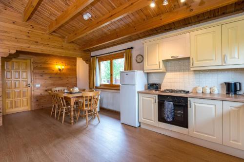 a kitchen with white appliances and a wooden ceiling at Teal Lodge in Market Rasen