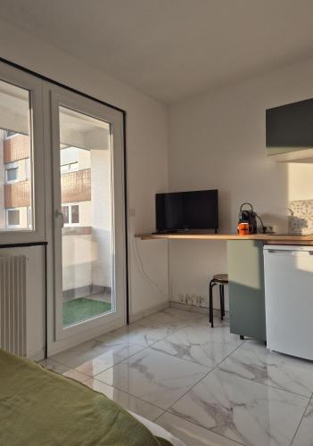 Cette chambre comprend une cuisine avec un comptoir et une fenêtre. dans l'établissement Le repos Alsacien, à Schiltigheim