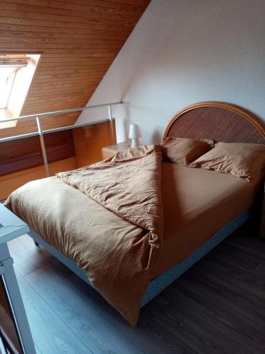 une chambre avec un lit avec une tête de lit en bois dans l'établissement Appartement vue sur la Baie de Somme - Magnifique terrasse, au Crotoy