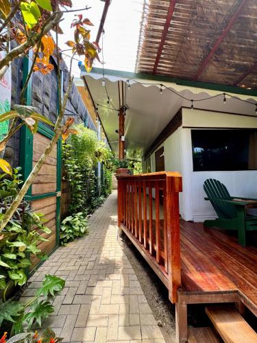 a wooden porch with a bench on a patio at Colibri Ecolodge 3 minutes walk to beach and town in Puerto Viejo