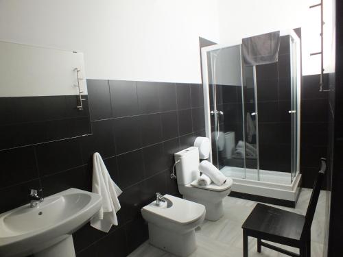 a bathroom with a sink and a toilet and a shower at JOY Plaza de Armas in Seville