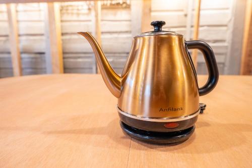 a metal tea kettle sitting on a wooden table at KAON Taisho renovated 100-year-old private house in Osaka