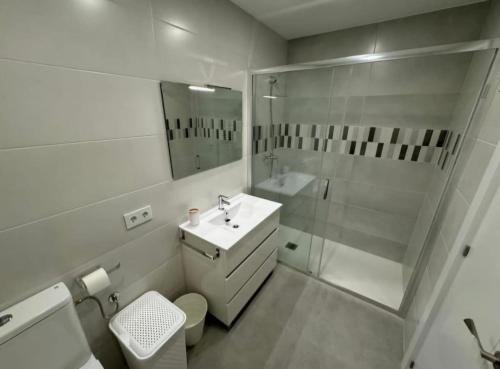 a white bathroom with a sink and a shower at Apartamento Araceli in Suances