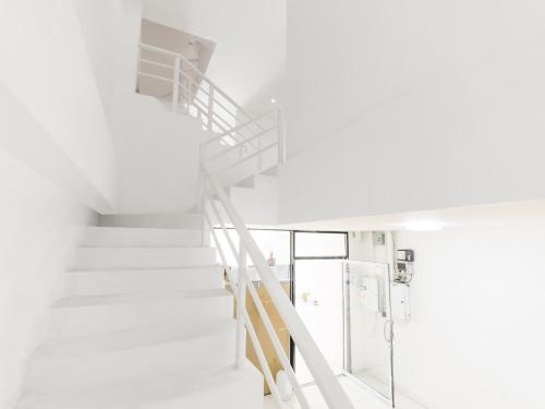 a spiral staircase in a white room with a stair case at MoonE in Ban Karon