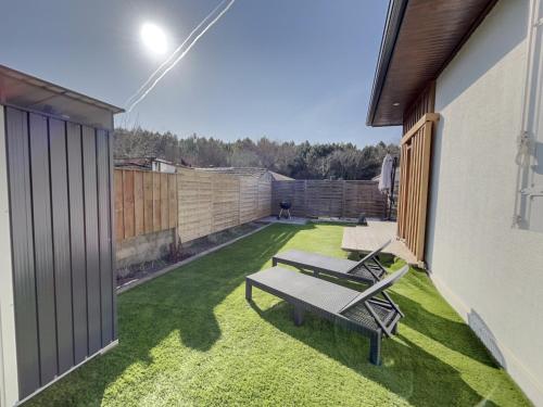 une petite arrière-cour avec un banc et de l'herbe dans l'établissement Le Baleste - Duplex Cosy, à Mimizan