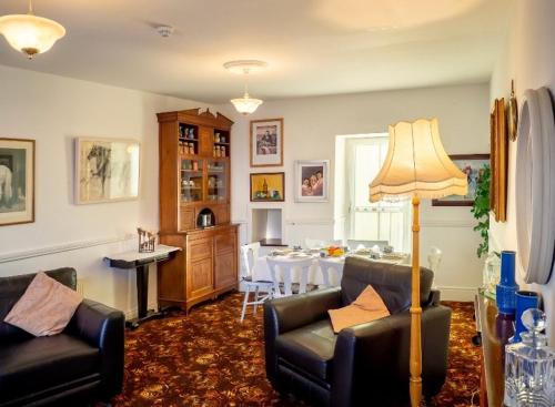 a living room with two couches and a dining room at White Heather 3 Bed Clifden Town in Clifden