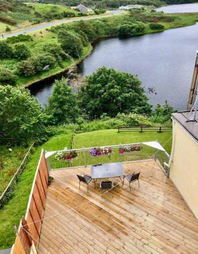 a wooden deck with a table and chairs on it at White Heather 3 Bed Clifden Town in Clifden