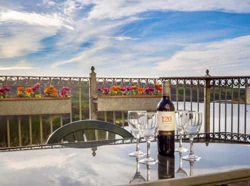 a bottle of wine and two wine glasses on a table at White Heather 3 Bed Clifden Town in Clifden