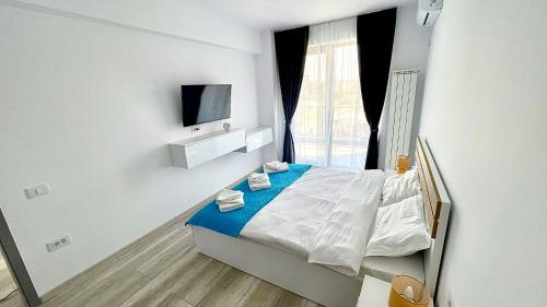a small bedroom with a bed and a television at Mamaia-Nord Boutique Apartments in Mamaia Sat/Năvodari