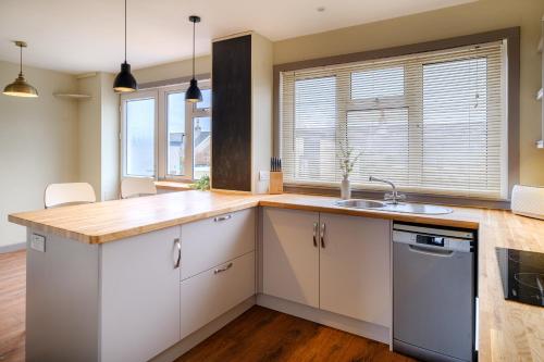 a kitchen with white cabinets and a wooden counter top at Banchory House - SJA Stays - 2 Bed House in Banchory