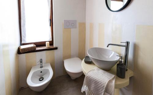 a bathroom with a tub and a sink and a toilet at Lo Stazzo Multa Bianca Relax Assoluto nella Natura in Pedrumalu