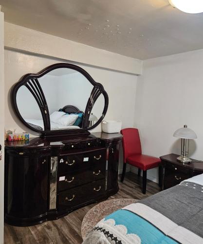 a bedroom with a dresser with a mirror on it at Queen bedroom in Toronto