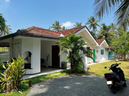 a scooter parked in front of a house at Leafy Madiha in Matara