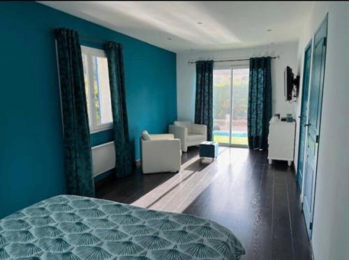 une chambre bleue avec un lit et un salon dans l'établissement Villa méditerranéenne saint Maximin la sainte baume, à Saint-Maximin-la-Sainte-Baume