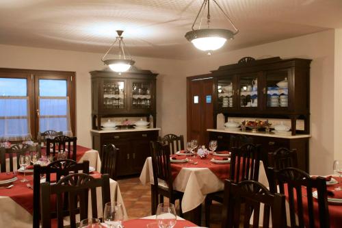 a dining room with tables and chairs with red table cloth at Hotel Rural Yeguada Albeitar in Villayón