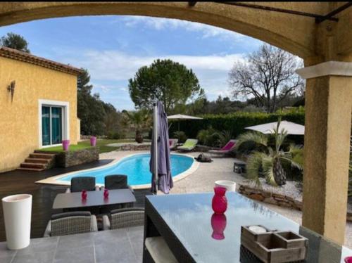 un patio avec une table et une piscine dans l'établissement Villa méditerranéenne saint Maximin la sainte baume, à Saint-Maximin-la-Sainte-Baume